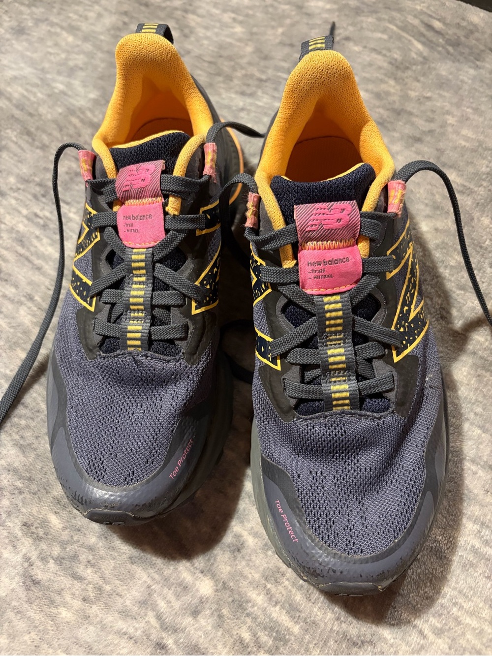 New Balance navy athletic sneakers with yellow and pink accents